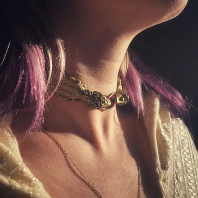 Collier ras de cou en galon doré et têtes de lions en laiton porté autour du cou