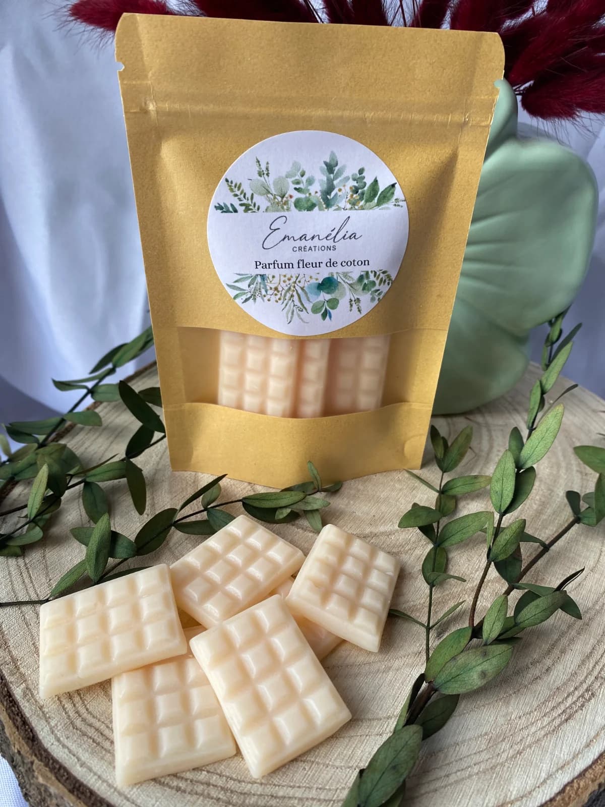 Lot de fondants parfumés blanc crème texturés façon tablettes devant leur sachet kraft à fenêtre.